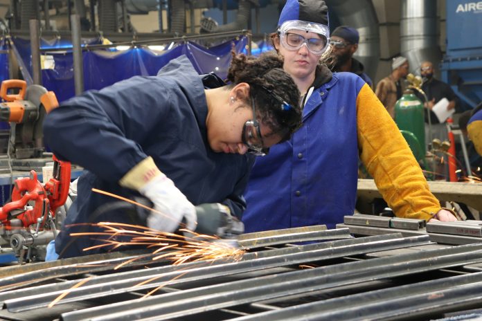 Two people cutting metal