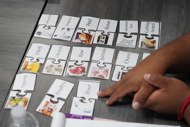 A person moving educational cards around to work on English