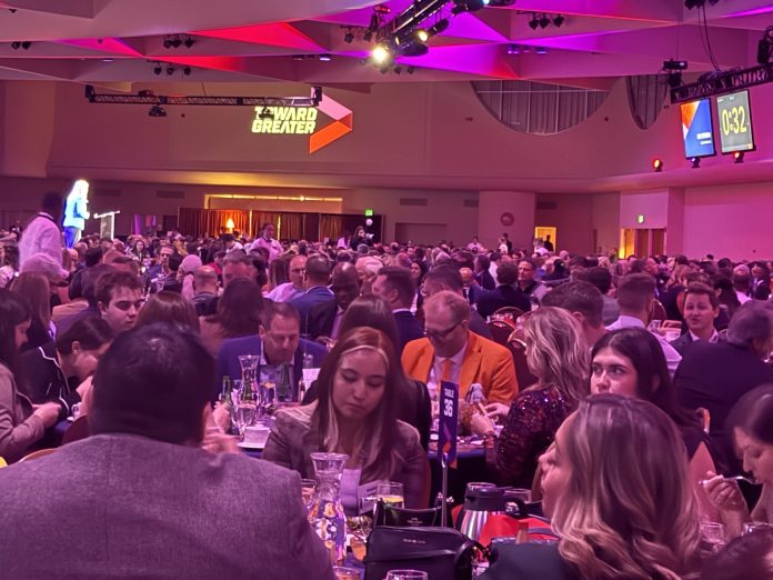 People sitting, eating, and drinking at an event